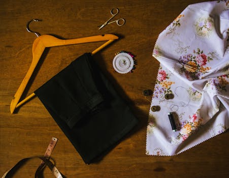 Sewing tools and fabric laid out for crafting on a wooden surface.