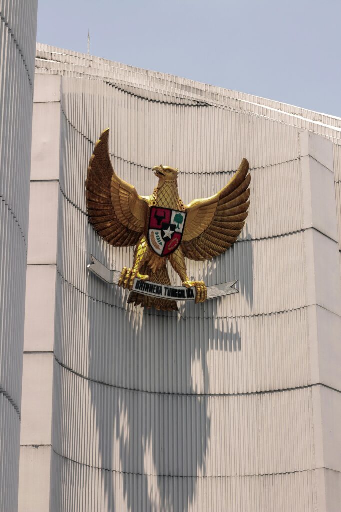 Vertical view of the Garuda Pancasila emblem on a building in Indonesia, symbolizing national unity.